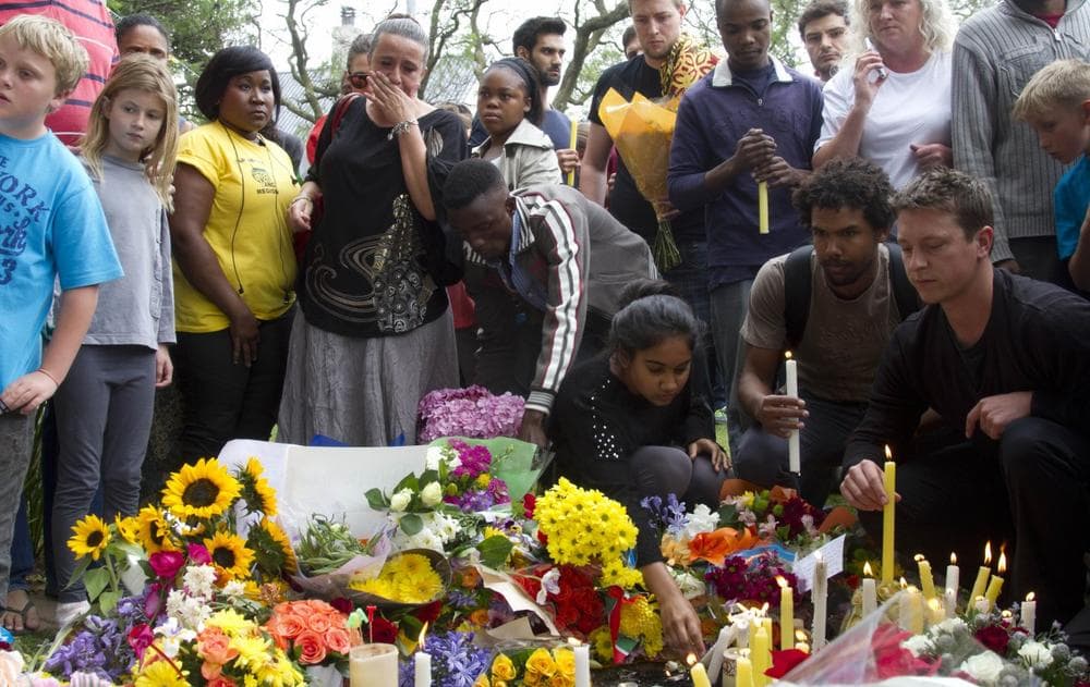 Mourners lay floral and candle tributes to former South African president Nelson Mandela outside his Johannesburg home, Friday, Dec. 6, 2013. (Athol Moralee/AP)