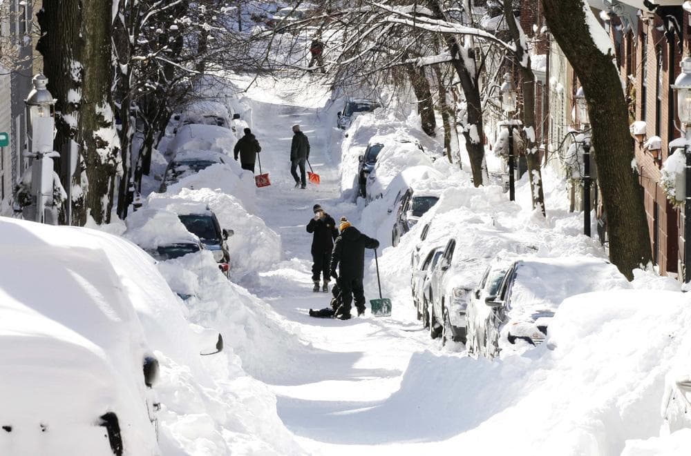 People dig out their cars after a snowstorm in Boston last February. (AP/File)