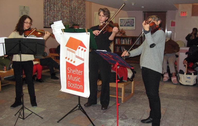 Musicians (left to right) Julie Leven, Rebecca Strauss and Julia McKenzie of Shelter Music Boston perform at the Pine Street Inn. (Sacha Pfeiffer/WBUR)