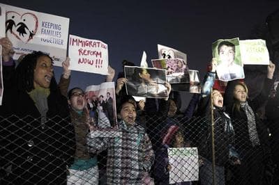 Immigration reform protesters gather outside the fence for the lighting of the 2013 U.S. Capitol Christmas Tree, an 88-foot Engelmann spruce, from the Colville National Forest, in northeast Washington State, during an event on Capitol Hill in Washington, Tuesday, Dec. 3, 2013. (AP)