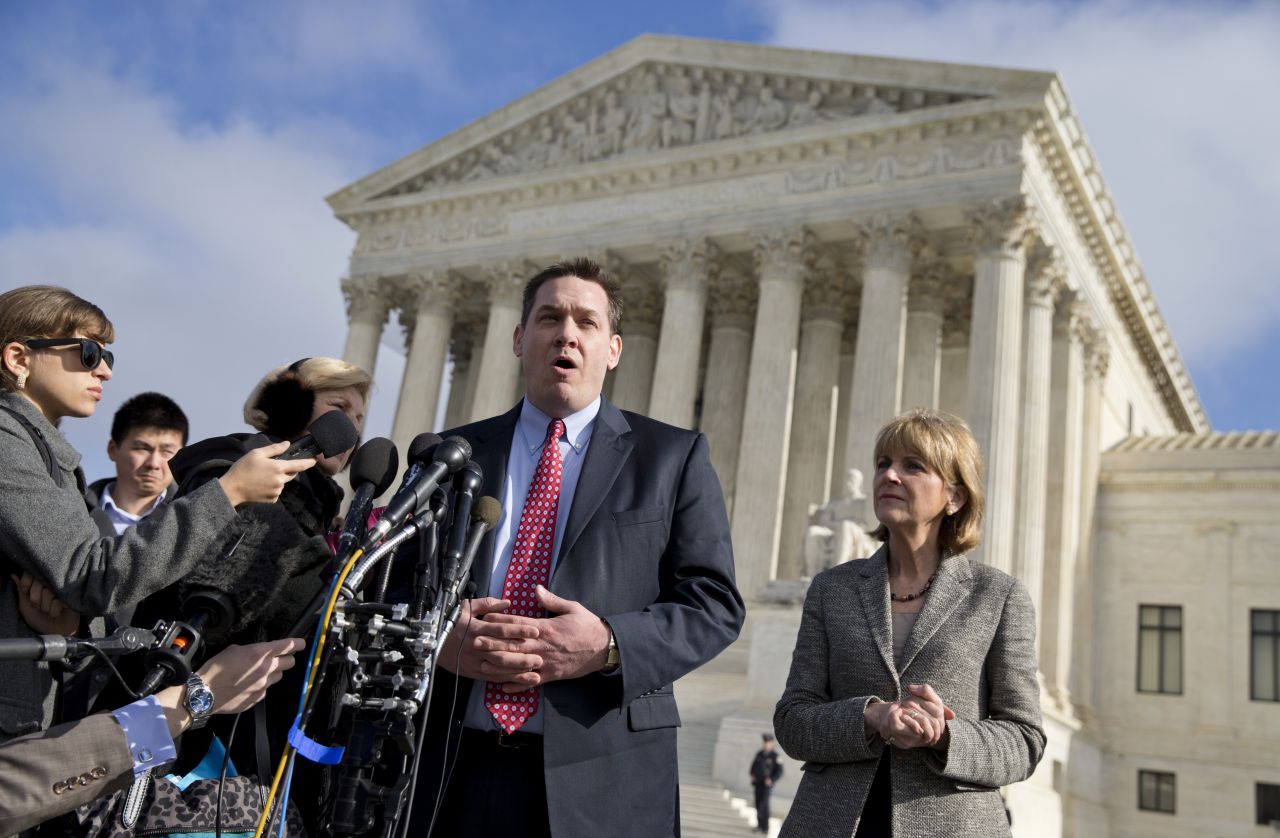 Massachusetts Attorney General Martha Coakley listens at right as Liam Lowney, whose sister Shanon was murdered while working at Planned Parenthood in 1994, speaks to reporters outside the Supreme Court in Washington. (Evan Vucci/AP)