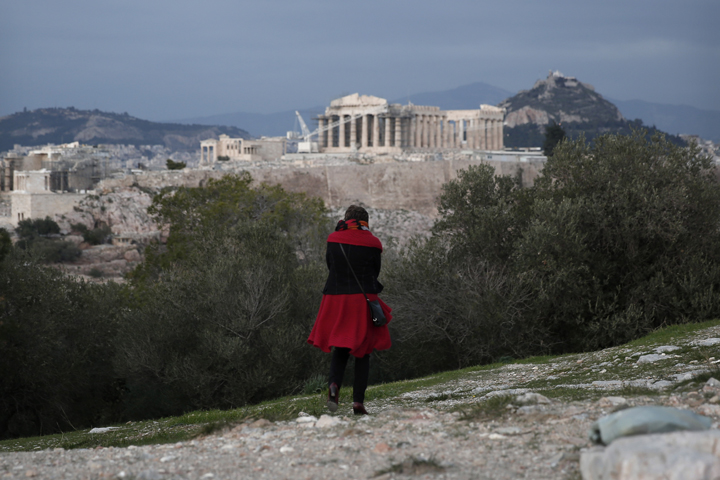 A tourist walks in front of the ancient Parthenon temple at the Acropolis hill Athens, on Thursday, Dec. 19, 2013. (AP)