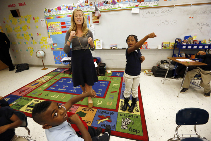 In this Feb. 15, 2013 photograph, Myrtle Hall IV Elementary School teacher Gabrielle Wooden, left, and Camilyn Anderson, 7, lead their first grade class in a live action Spanish class in Clarksdale, Miss. Students attend a language immersion magnet school where Spanish is taught. (AP)