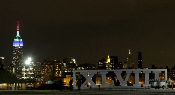 People watch fireworks as they stand near the Roman numerals for NFL Super Bowl XLVIII at Pier A Park in Hoboken, New Jersey. (AP/Julio Cortez)