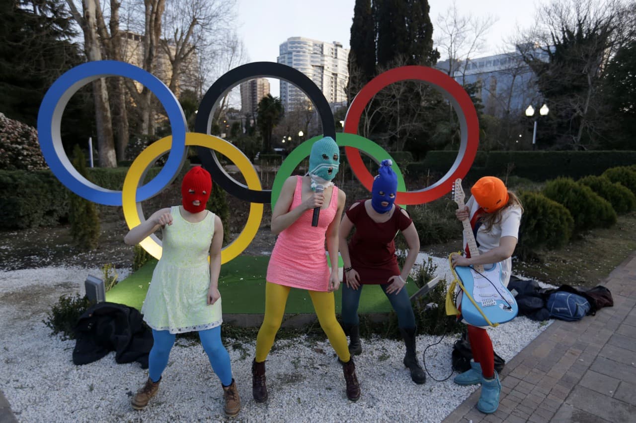 Members of the punk group Pussy Riot perform next to the Olympic rings in Sochi, Russia, on Wednesday, Feb. 19, 2014. Cossack militia attacked the punk group with horsewhips earlier in the day as the artists - who have feuded with Vladmir Putin's government for years - tried to perform under a sign advertising the Sochi Olympics. (David Goldman/AP)