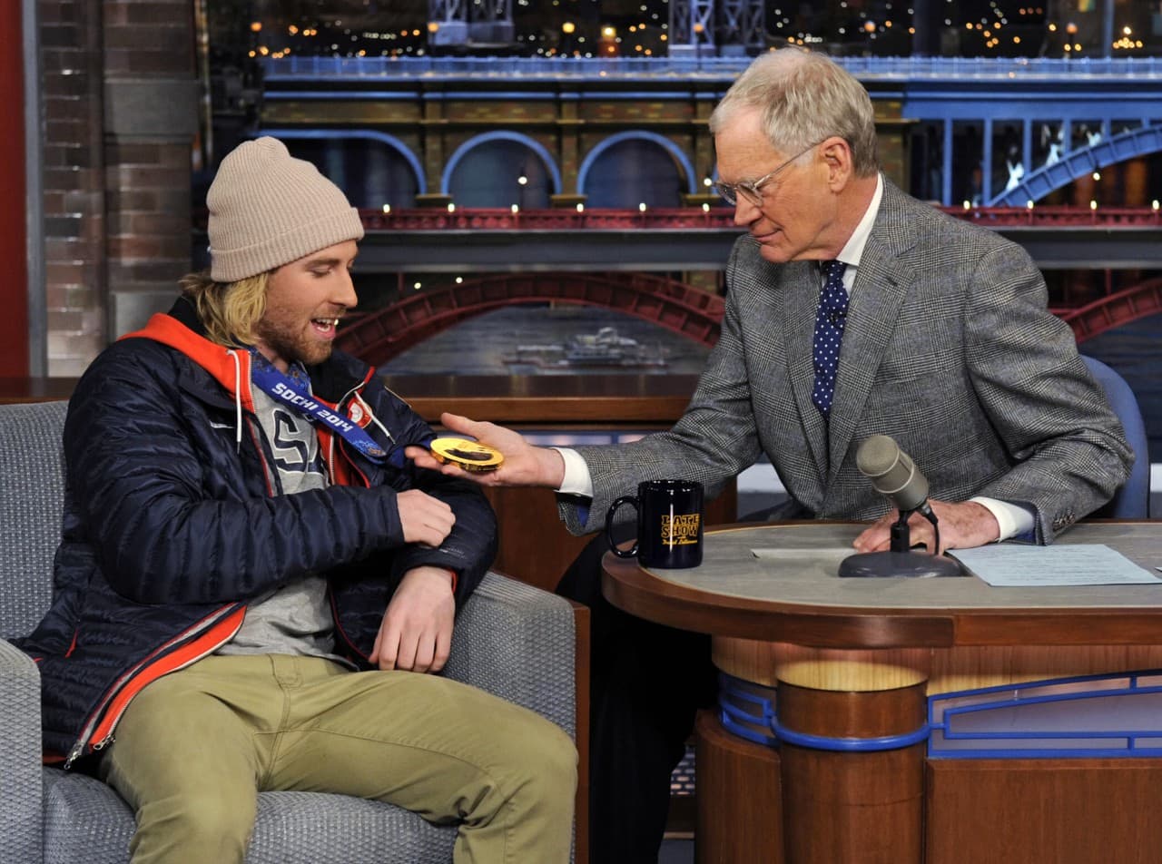 David Letterman, right, examines U.S. Olympic men’s slopestyle gold medalist Sage Kotsenburg’s medal on the set of “Late Show with David Letterman,” Tuesday Feb. 18, 2014, in New York. (Jeffrey R. Staab/CBS/AP)
