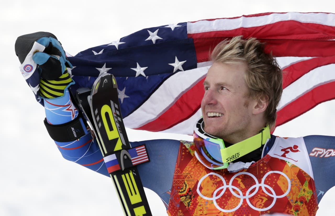 Men's giant slalom gold medalist Ted Ligety poses for photographers with the American flag on the podium at the Sochi 2014 Winter Olympics, Wednesday, Feb. 19, 2014, in Krasnaya Polyana, Russia. (Charles Krupa/AP)