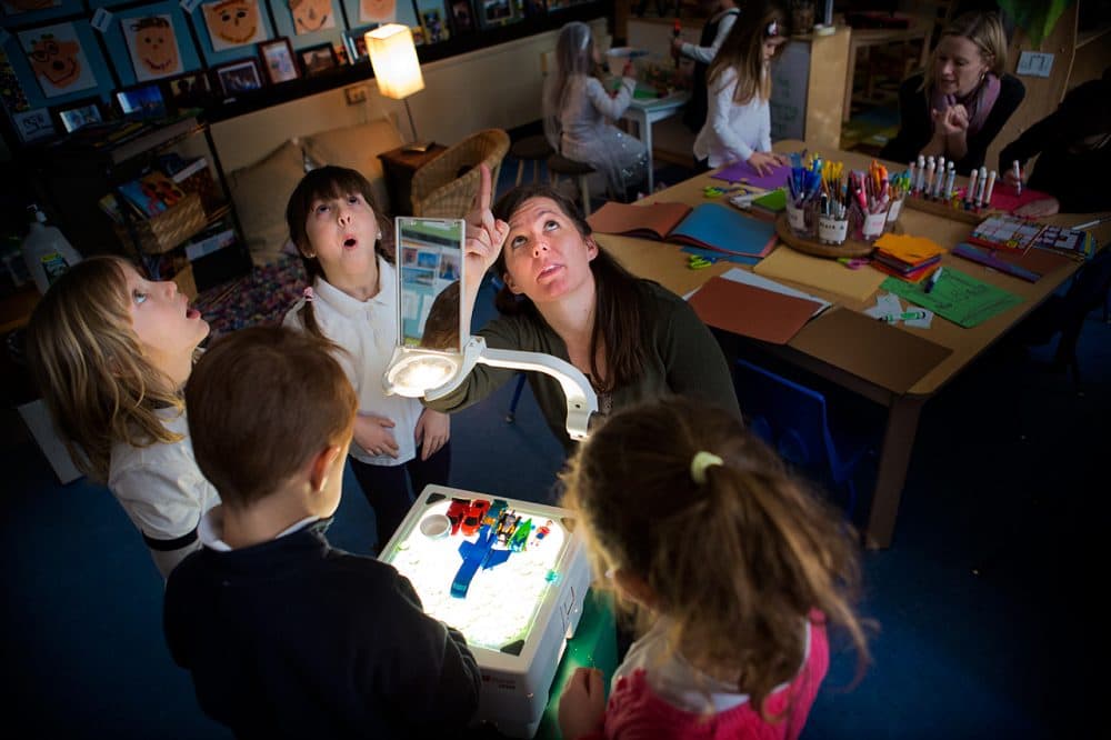 Using a projector, Jodi Doyle points out shadows on the ceiling to students of her preschool class at the Eliot K-8 Innovation School in Boston's North End. (Jesse Costa/WBUR)