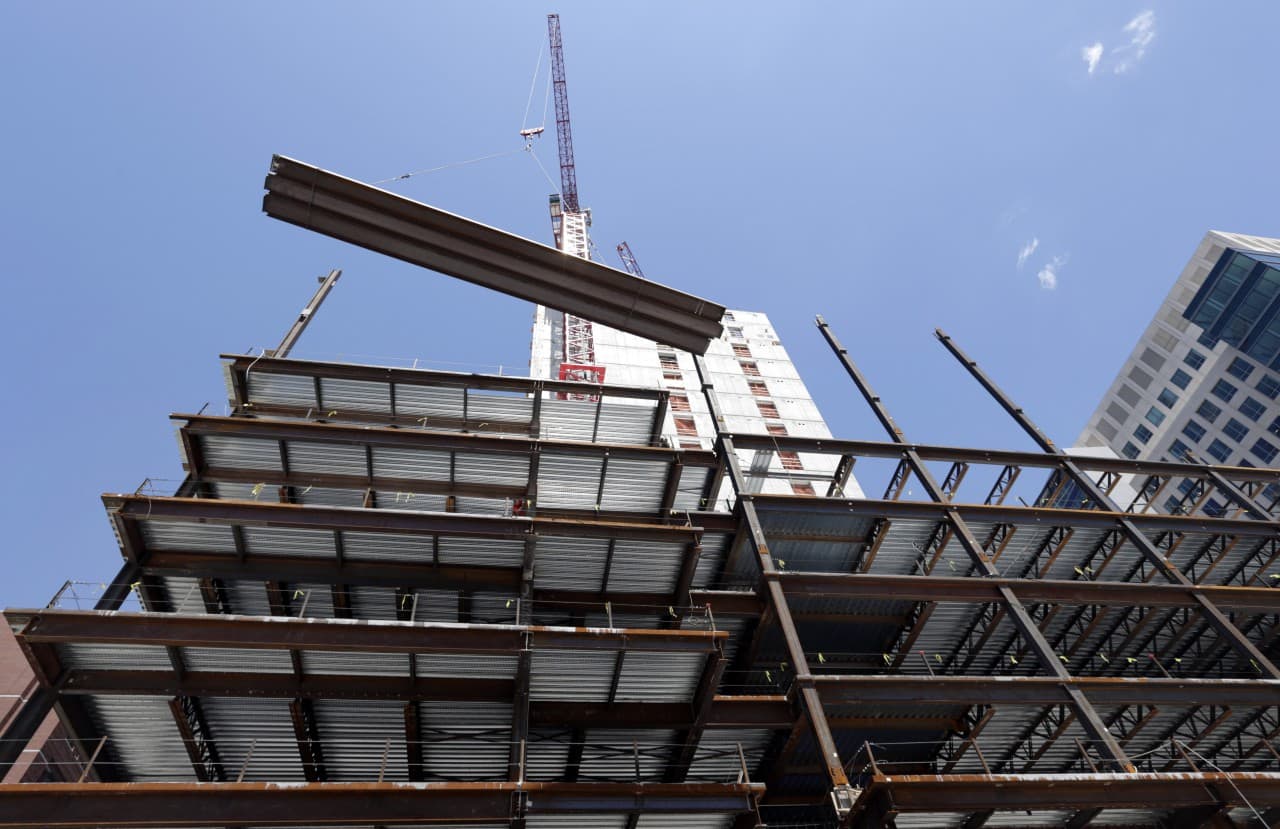 A large beam is lifted by a crane at a construction site in Boston. (AP/Elise Amendola)