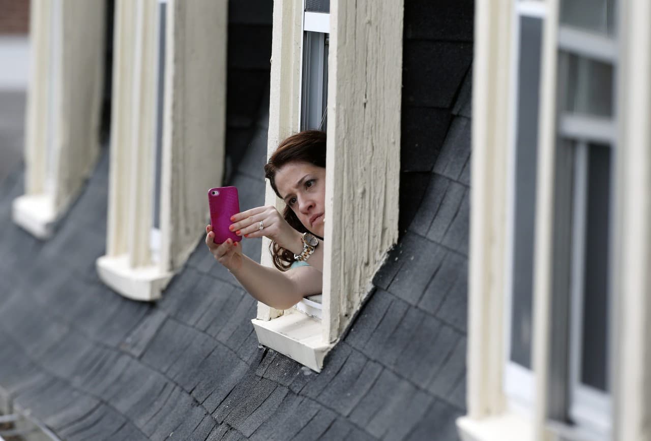 A resident records the scene around Norfolk Street in Cambridge, April 19, 2013 as authorities search for Boston Marathon bombing suspect, Dzhokhar Tsarnaev. (Michael Dwyer/AP)