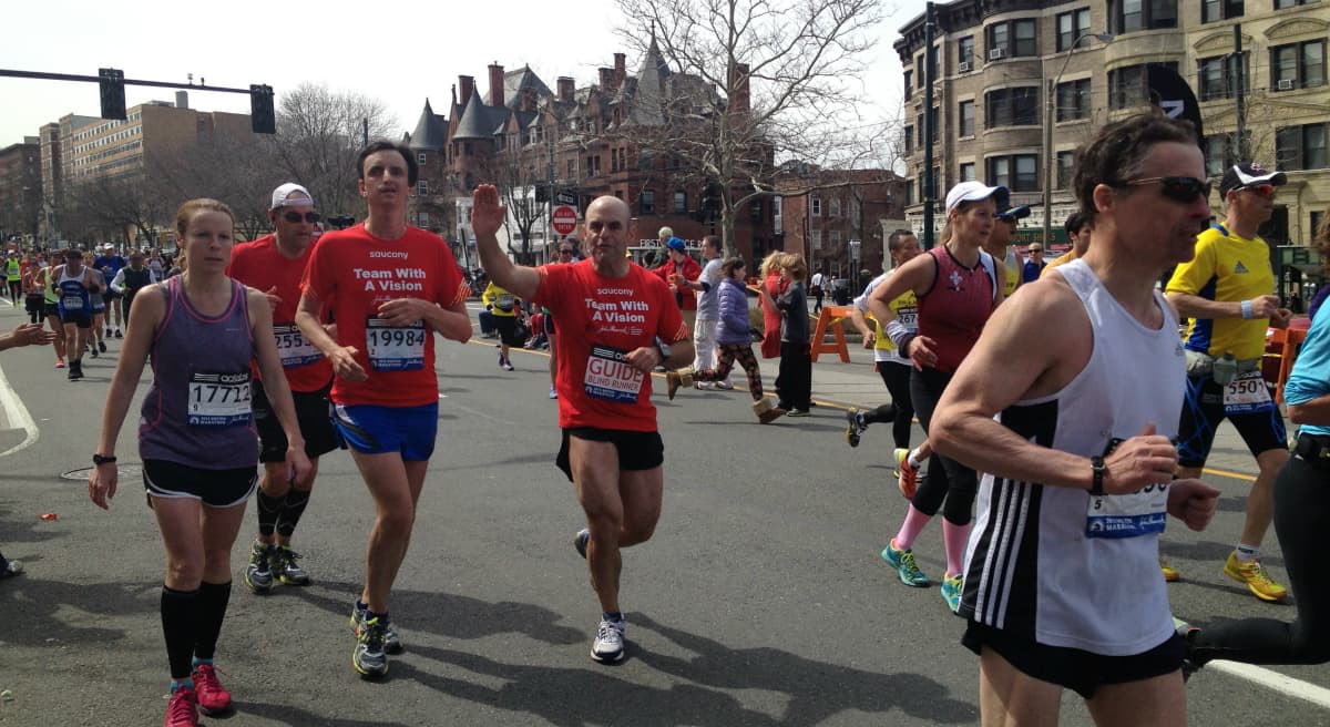 Peter Sagal runs next to William Greer around Mile 24 of the 2013 Boston Marathon. This picture was taken roughly 20 minutes before the bombs went off. (Linda McIntosh/Courtesy)