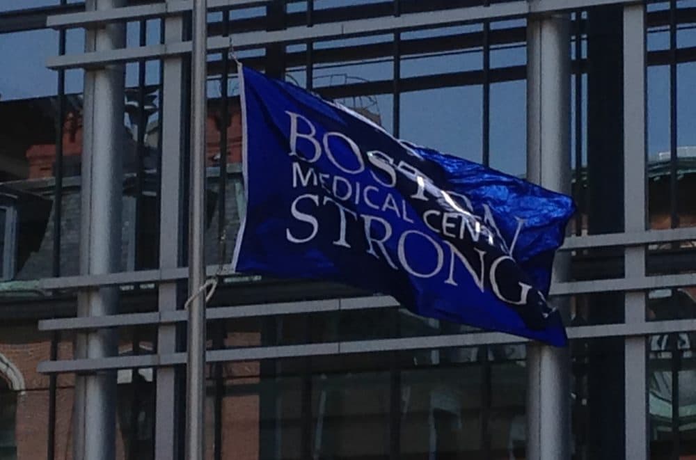 A flag that says &quot;Boston Medical Center Strong&quot; waves outside of Boston Medical Center, a year after the Boston Marathon bombing. (Ron Medzon)