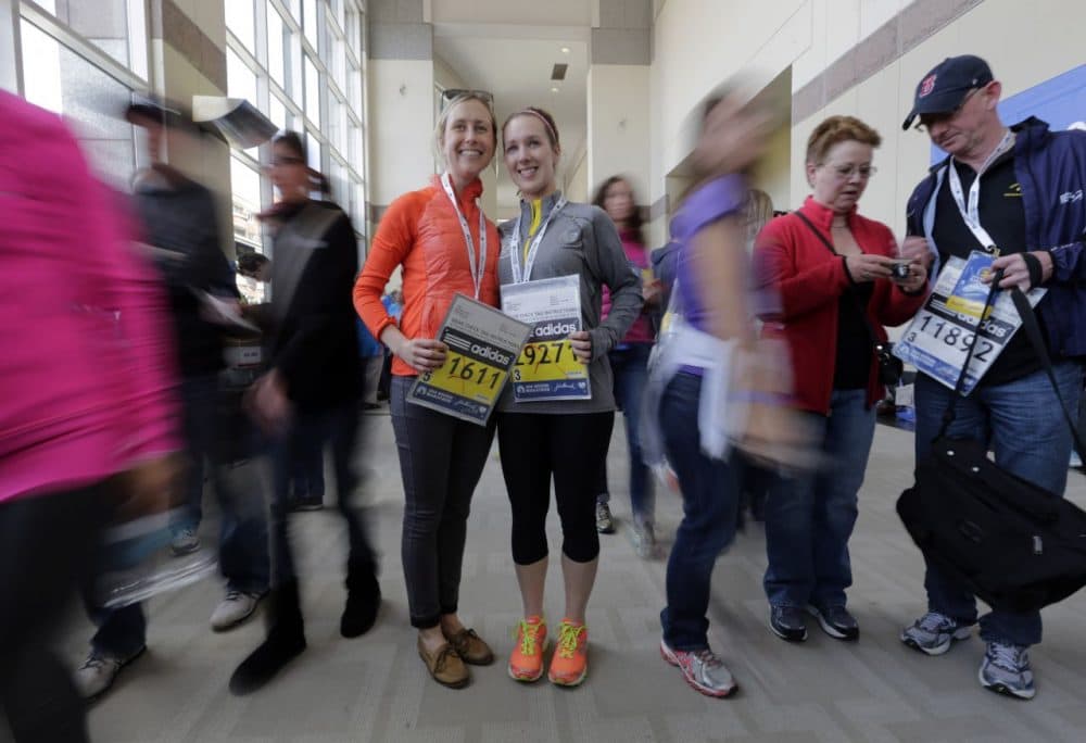 Cousins Laura Snebold, left, of Washington, and Christine Kenney, of Dedham, Mass., display their bibs to run in Monday's 118th Boston Marathon after picking them up Saturday, April 19, 2014, in Boston. (Robert F. Bukaty/AP)