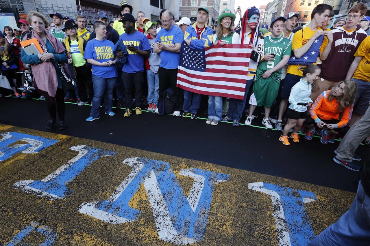 A crowd gathers at the finish line of the Boston Marathon in Boston for a Sports Illustrated photo shoot before the one-year anniversary of the Boston Marathon bombings, Saturday, April 12, 2014. (AP)