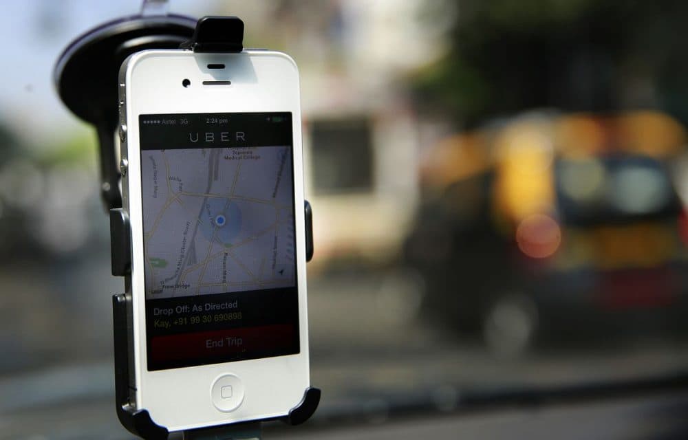 A smartphone is mounted on the glass of an Uber car. (Rafiq Maqbool/AP)