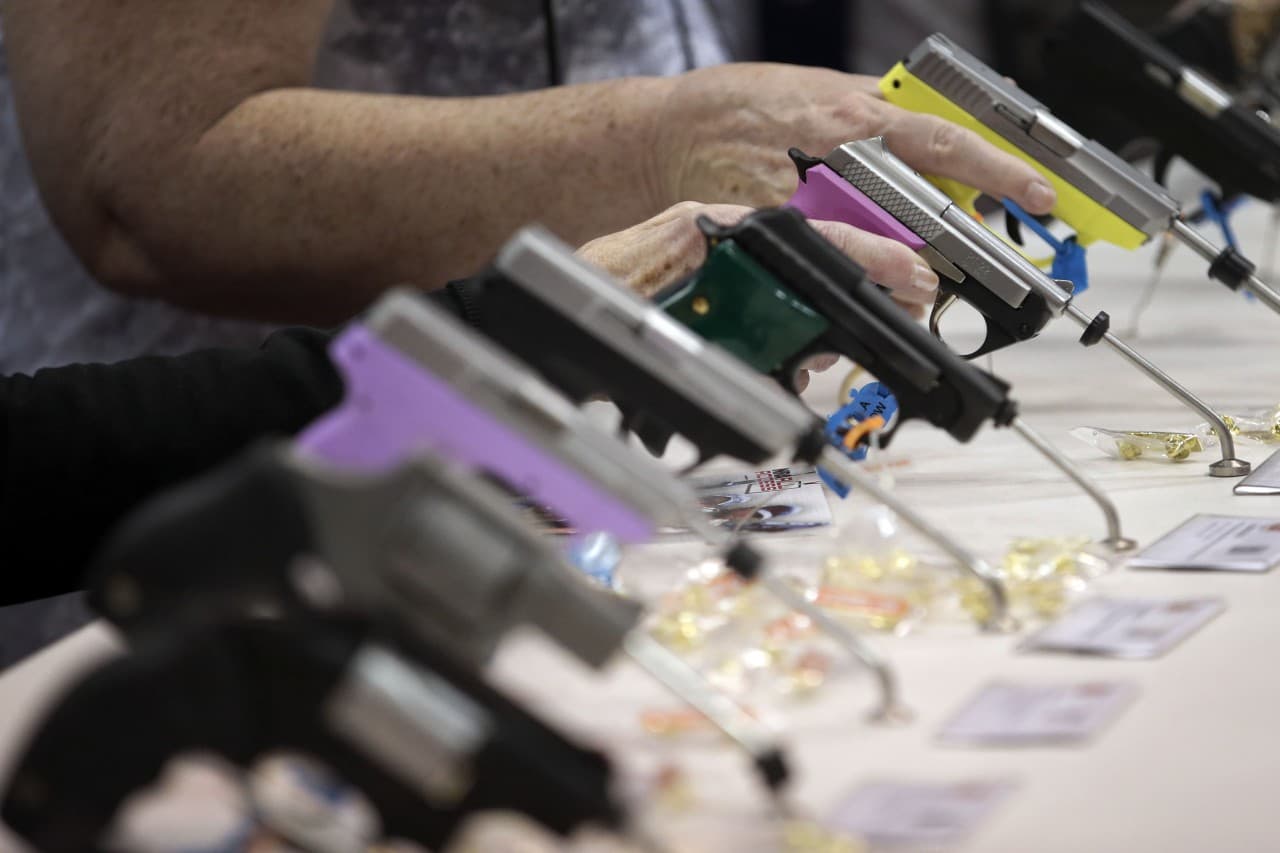 Attendees look over a pistol display at the National Rifle Association's annual convention in Friday, April 25, 2014 in Indianapolis. (AP)