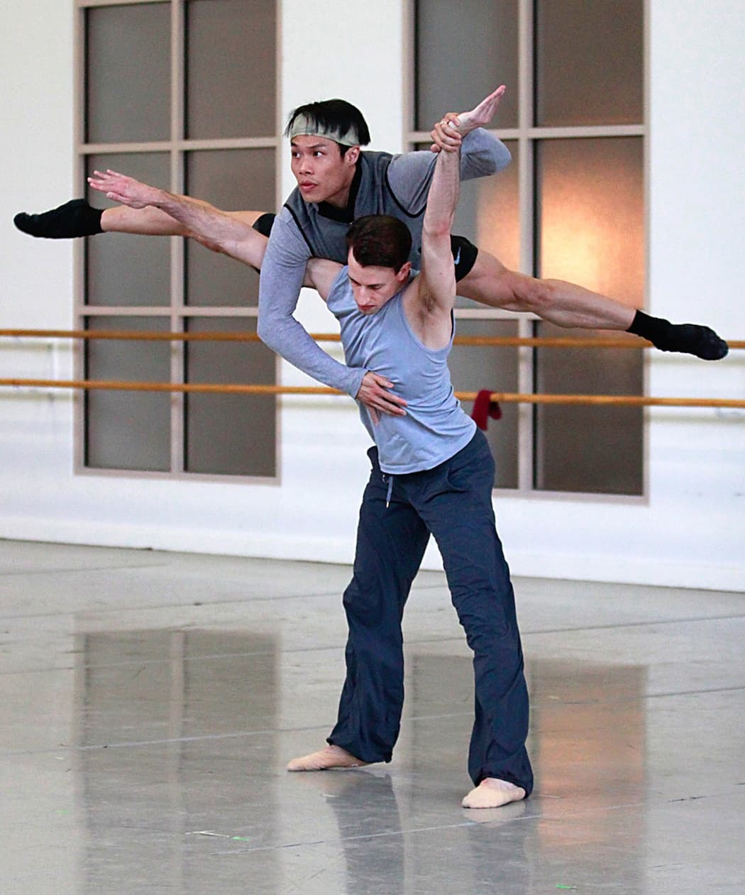 Bradley Schlagheck lifts John Lam in a rehearsal for Petr Zuska’s “D.M.J. 1953-1977.” (Lawrence Elizabeth Knox)