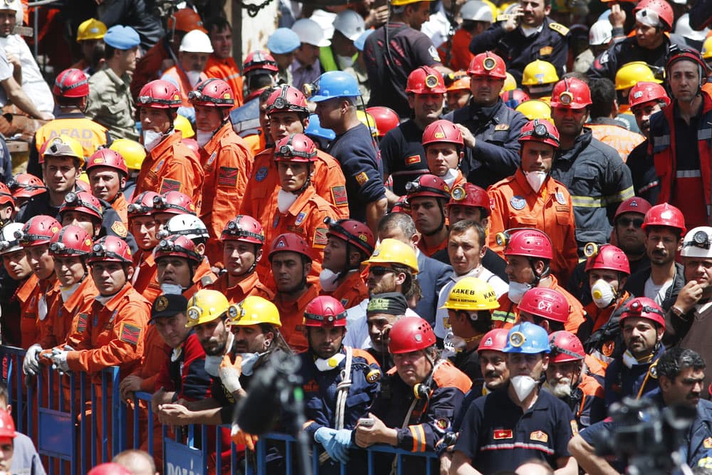 Miners and members of the rescue services wait for the arrival of Turkey's President Abdullah Gul outside the mine in Soma, western Turkey, Thursday, May 15, 2014. An explosion and fire at a coal mine in Soma, some 250 kilometers (155 miles) south of Istanbul, killed hundreds of workers, authorities said, in one of the worst mining disasters in Turkish history. (AP)