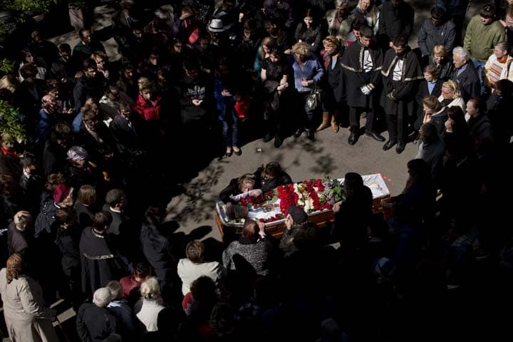 People gather around the coffin of 17 year-old Vadim Papura during a religious service outside the apartment block he lived in, in Odessa, Ukraine, Tuesday, May 6, 2014. Papura died after jumping out of the burning trade union building in an attempt to escape Friday's fire that killed most of the 40 people that died after riots erupted last Friday. (AP)