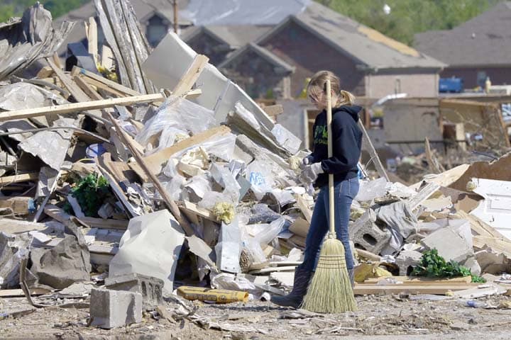Harlee Branson, 13, uses a broom to help clean up storm rubble on her grandparents' property near a Vilonia, Ark., neighborhood Thursday, May 1, 2014. A tornado struck the town late Sunday. (AP)