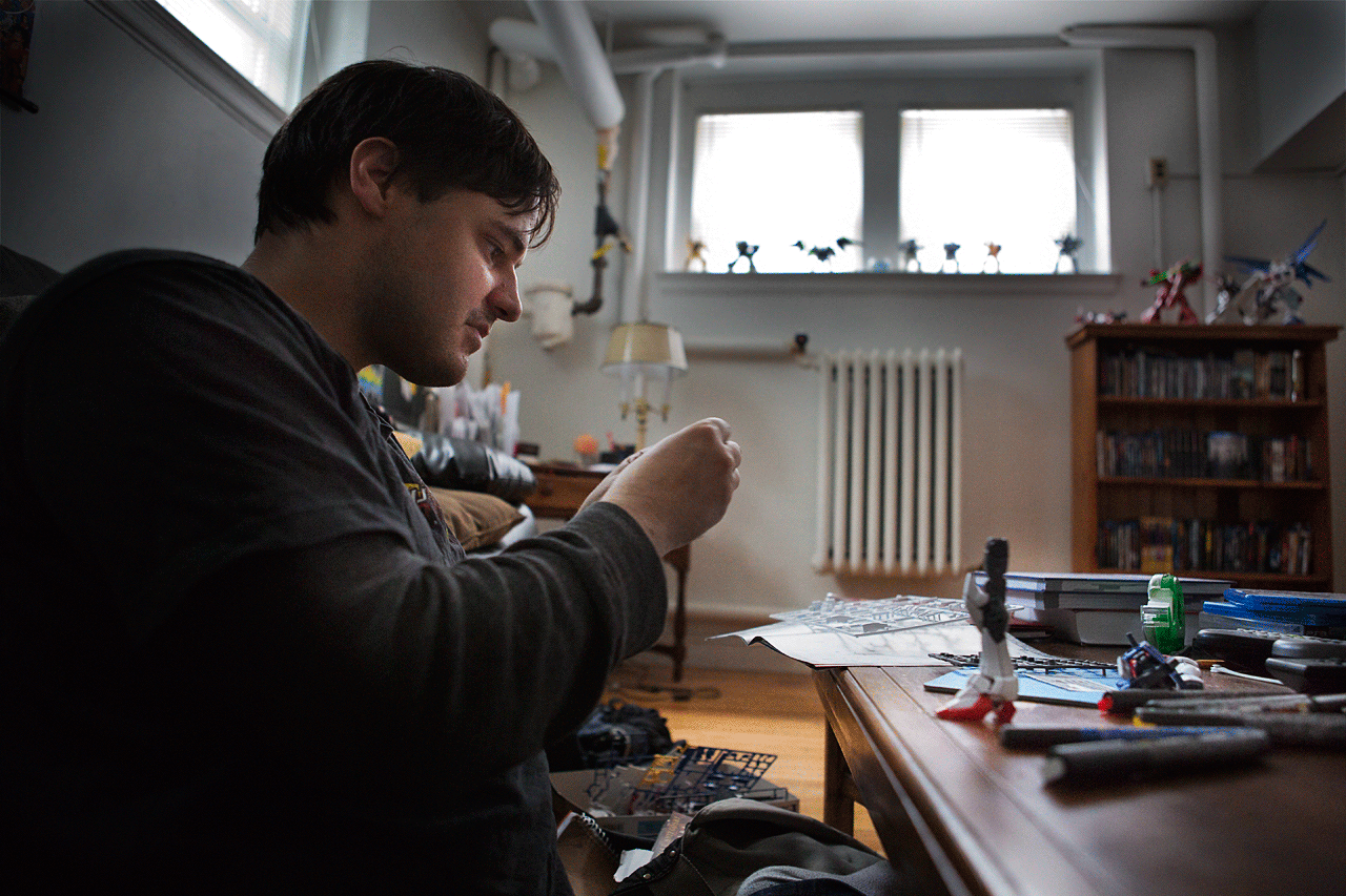 Michael Moscariello works on an anime character PVC model in his apartment. (Jesse Costa/WBUR)
