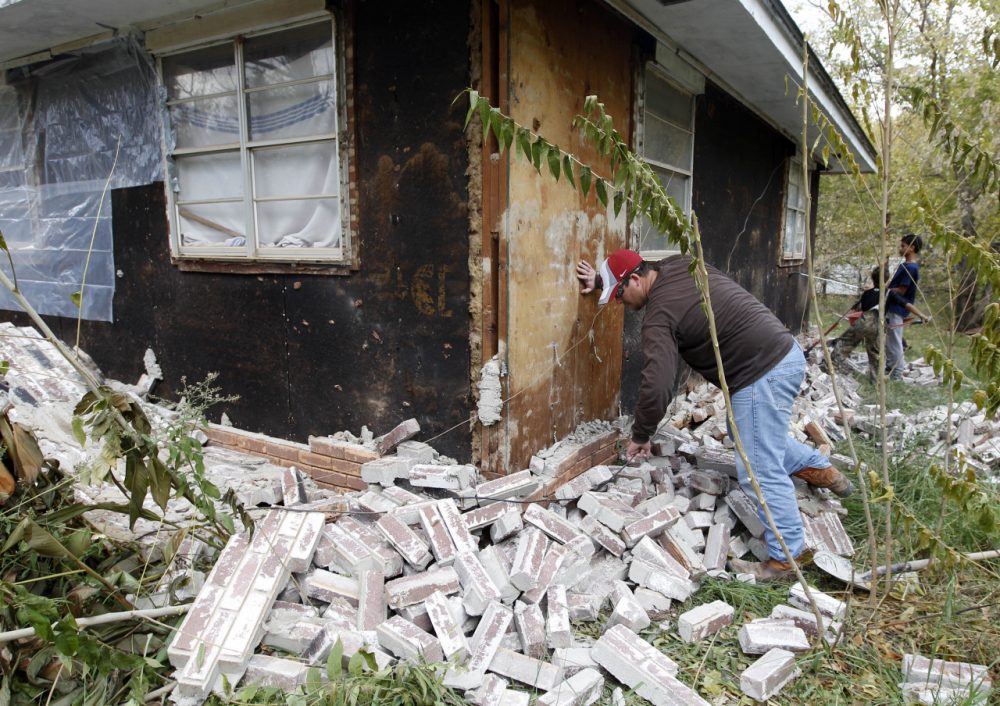 Chad Devereaux examines bricks that fell from three sides of his in-laws home in Sparks, Okla., Nov, 6, 2011, following two earthquakes that hit the area in less than 24 hours. (Sue Ogrocki/AP)