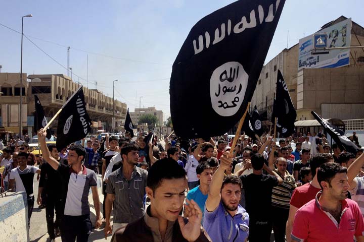In this Monday, June 16, 2014 file photo, Demonstrators chant pro-al-Qaida-inspired Islamic State of Iraq and the Levant (ISIL) as they carry al-Qaida flags in front of the provincial government headquarters in Mosul, 225 miles (360 kilometers) northwest of Baghdad, Iraq. (AP)