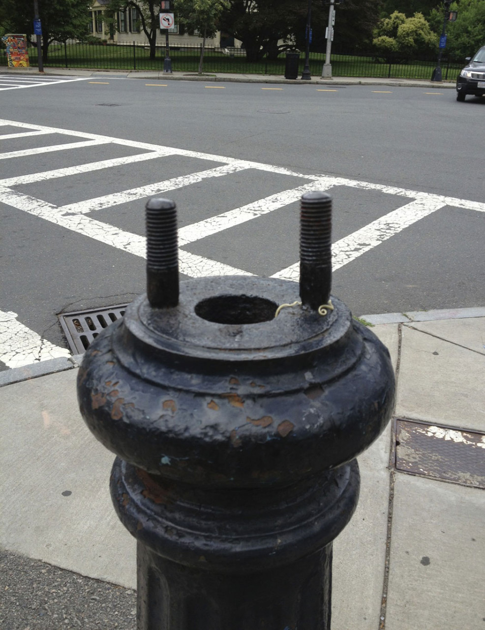 Before: The tempting screws atop the stump of the lamppost in Jamaica Plain’s Monument Square. (Courtesy)