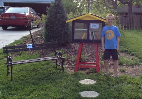Spencer Collins, 9, with his Little Free Library that a neighbor complained  was an eyesore and violated the town's zoning ordinances. (Sarah Collins)