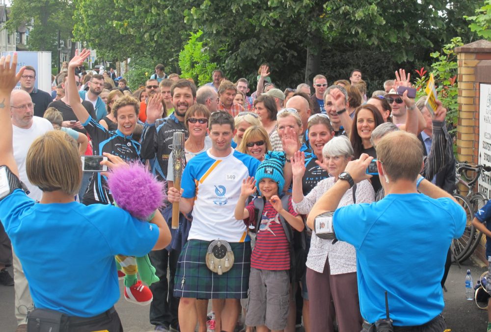 A member of the Queen's Baton Relay in the Scotstoun section of Glasgow, Scotland poses for photographs before beginning his (short) portion of the 190,000 km relay. The baton is en route to the Commonwealth Games Opening Ceremony. (Doug Tribou/Only A Game)