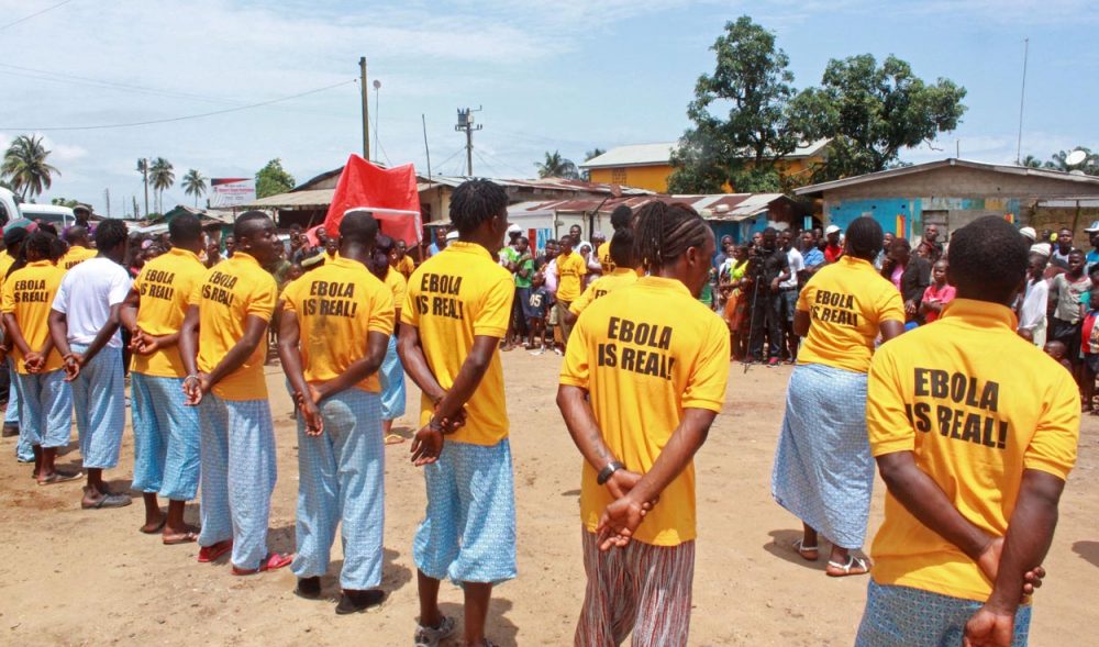 People working for a petroleum company take part in an Ebola awareness campaign in Liberia on Monday. (Abbas Dulleh/AP)