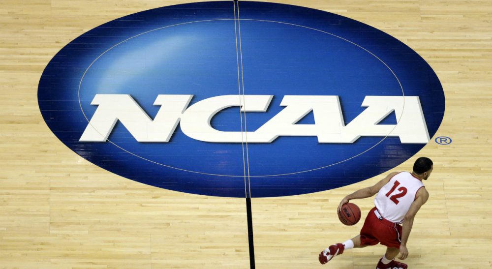 E. M. Swift: "The tide is moving inexorably against the NCAA’s traditional definition of amateurism." Pictured: Wisconsin's Traevon Jackson dribbles past the NCAA logo during practice at the NCAA men's college basketball tournament in Anaheim, Calif., March 26, 2014. U.S. District Judge Claudia Wilken in Oakland, Calif., ruled in favor of former UCLA basketball star Ed O'Bannon and 19 others in a lawsuit that challenged the NCAA's regulation of college athletics on antitrust grounds. (Jae C. Hong/AP)