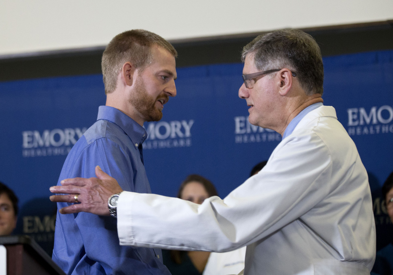 Ebola victim Dr. Kent Brantly, left, embraces Dr. Bruce Ribner, medical director of Emory’s Infectious Disease Unit, after being released from Emory University Hospital, Thursday, Aug. 21, 2014, in Atlanta. (John Bazemore/AP)
