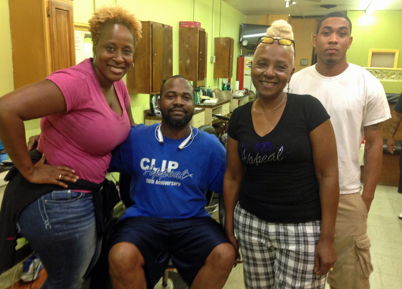 Buffi Blanchard, Ikiao Jones, Kaye Mershon and Jared Scott pose for a photo at Clip Appeal barbershop in Ferguson. (Deborah Becker)