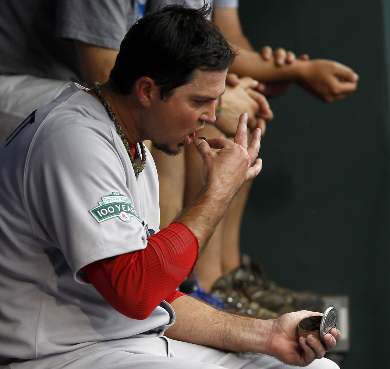 In this AP file photo, former Red Sox starting pitcher Josh Beckett inserts smokeless tobacco as he sits on the bench. (Alex Brandon/AP)