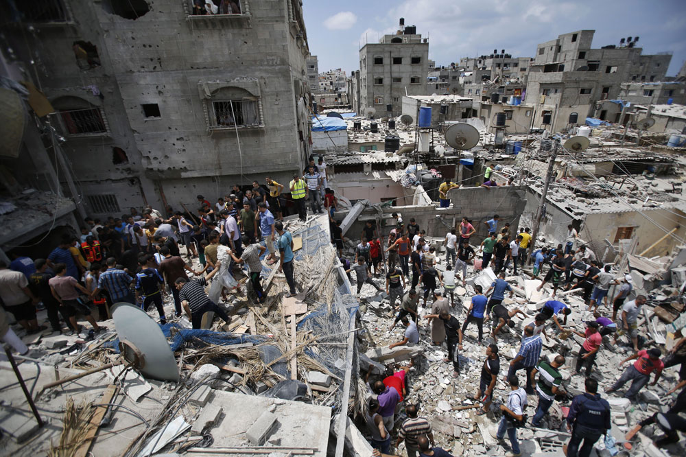 Palestinians look for survivors under the rubble of the al-Bakri family home destroyed by an Israeli strike in Gaza City, Monday, Aug. 4, 2014. (AP/Hatem Moussa)