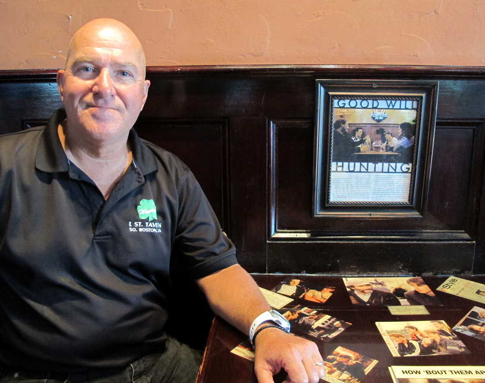 Ron Rumble, manager of L Street Tavern, at a table with "Good Will Hunting" paraphernalia (Andrea Shea/WBUR)