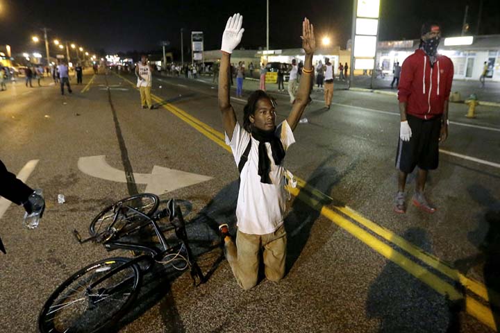 A man holds his hands up in the street after a standoff with police Monday, Aug. 18, 2014, during a protest for Michael Brown, who was killed by a police officer Aug. 9 in Ferguson, Mo. (AP)