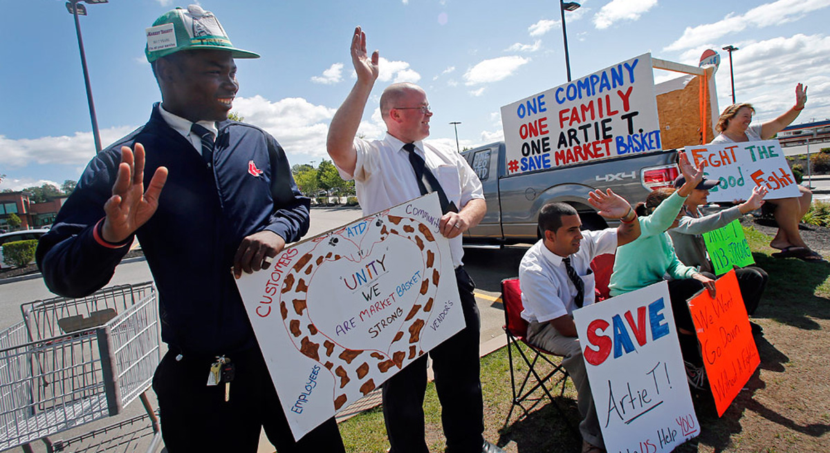 The recent Market Basket dispute demonstrates that America's labor law is in dire need of reform. Pictured: Market Basket employees hold signs and wave to passing supporters outside the supermarket in Haverhill, Mass., Monday, Aug. 18, 2014. (Elise Amendola/AP)