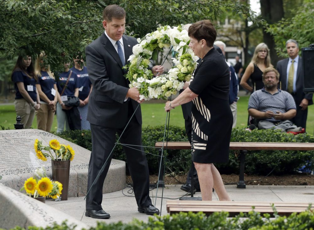 Boston Mayor Martin Walsh, left, and Maureen Gilligan place a wreath during a ceremony commemorating the anniversary of the 9/11 terrorist attacks at a memorial at the Public Garden in Boston. (Steven Senne/AP)