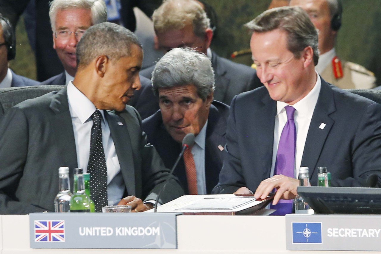 Secretary of State John Kerry, center, talks with President Barack Obama as British Prime Minister David Cameron, right, finishes speaking at a meeting of NATO leaders regarding Afghanistan at the NATO summit at Celtic Manor in Newport, Wales, Thursday, Sept. 4, 2014.  (AP)