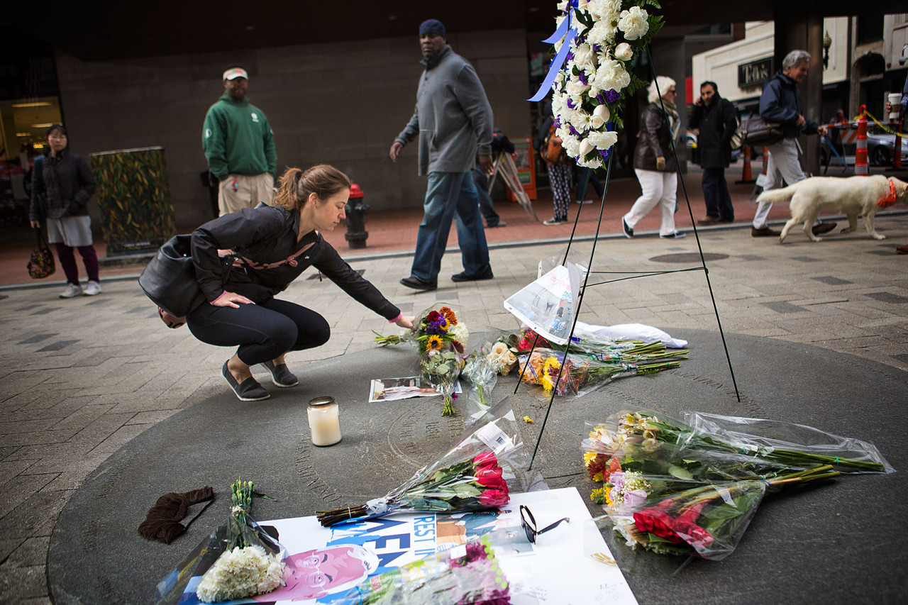 Jessica Sousa, of Somerville, leave flowers to honor the late former mayor of Boston Thomas Menino at a Memorial at Downtown Crossing. (Jesse Costa/WBUR)