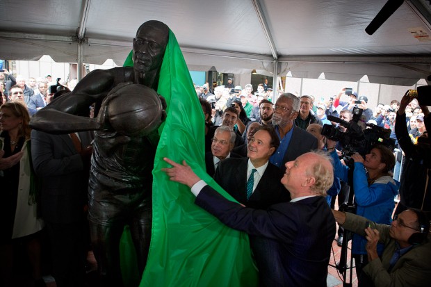 Boston Mayor Thomas Menino, Celtics managing partner Stephen Pagliuca, center, and Bill Russell watch as Bill Russell Legacy Committee member Bobby Sager unveils the Bill Russell statue on City Hall Plaza. (Jesse Costa/WBUR)
