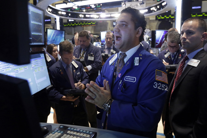 Specialist Ronnie Howard, center, calls out prices as he works at his post on the floor of the New York Stock Exchange Thursday, Oct. 16, 2014. Beyond the turmoil shaking financial markets, the U.S. economy remains sturdier than many seem to fear. (AP)