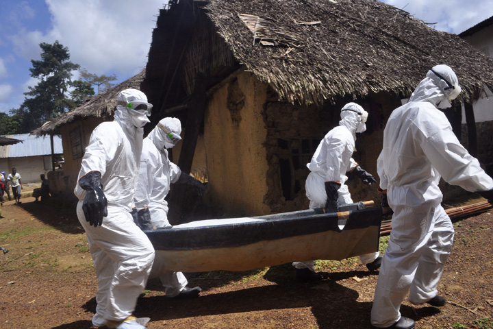 Health workers carry the body of a woman suspected of contracting the Ebola virus in Bomi county situated on the outskirts of Monrovia, Liberia, Monday, Oct. 20, 2014. (AP)