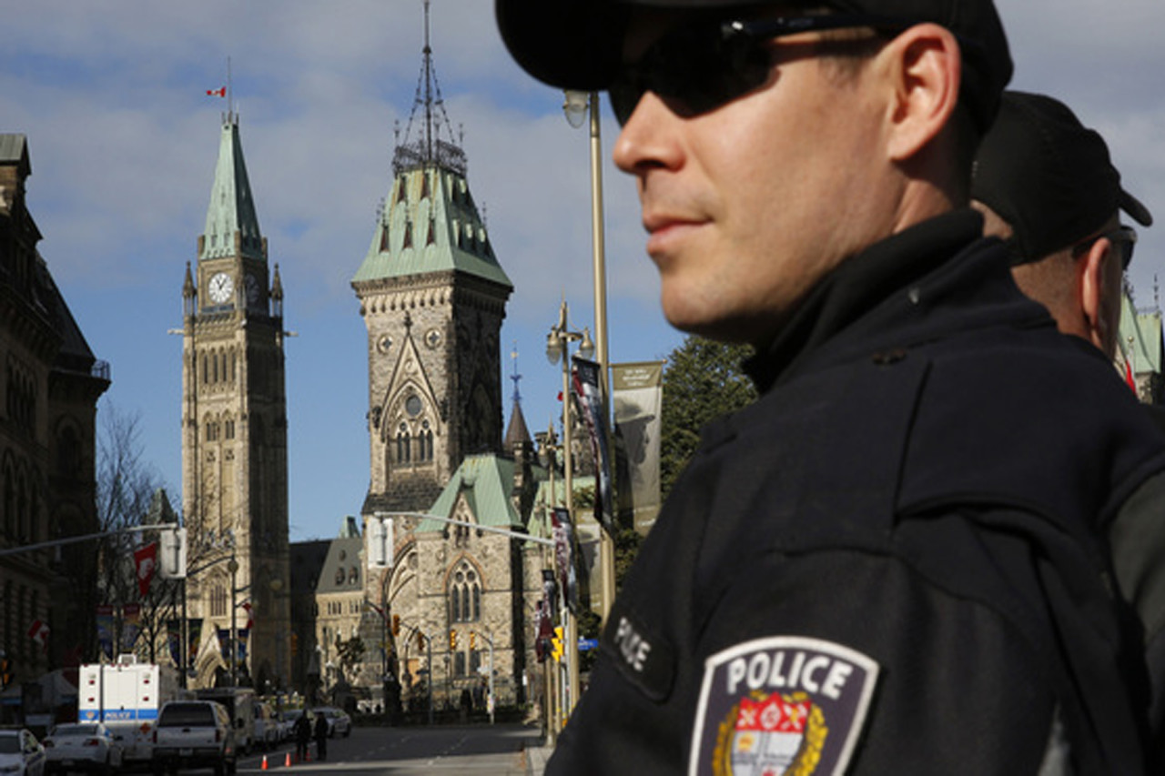 Ottawa police officers, with Parliament Hill in the background, guard the area around the National War Memorial in downtown Ottawa on Thursday. (Reuters/Landov)