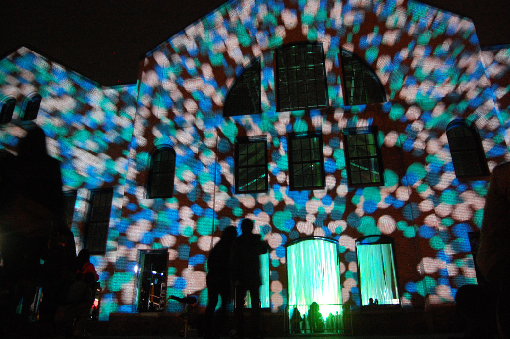 Polka dots are projected across the facade of the old power plant. (Greg Cook)