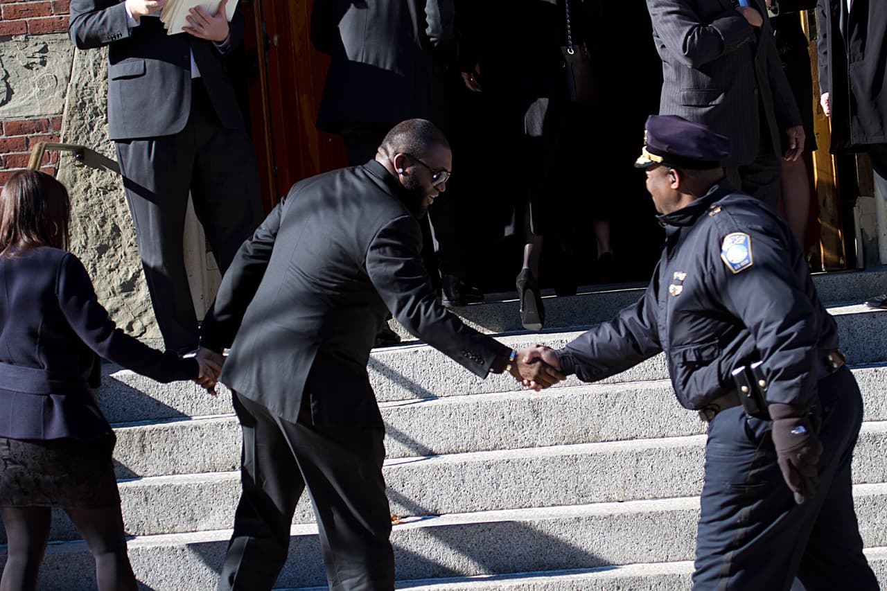 Red Sox star David Ortiz shakes hands with a police officer as he enters the church. (Jesse Costa/WBUR)