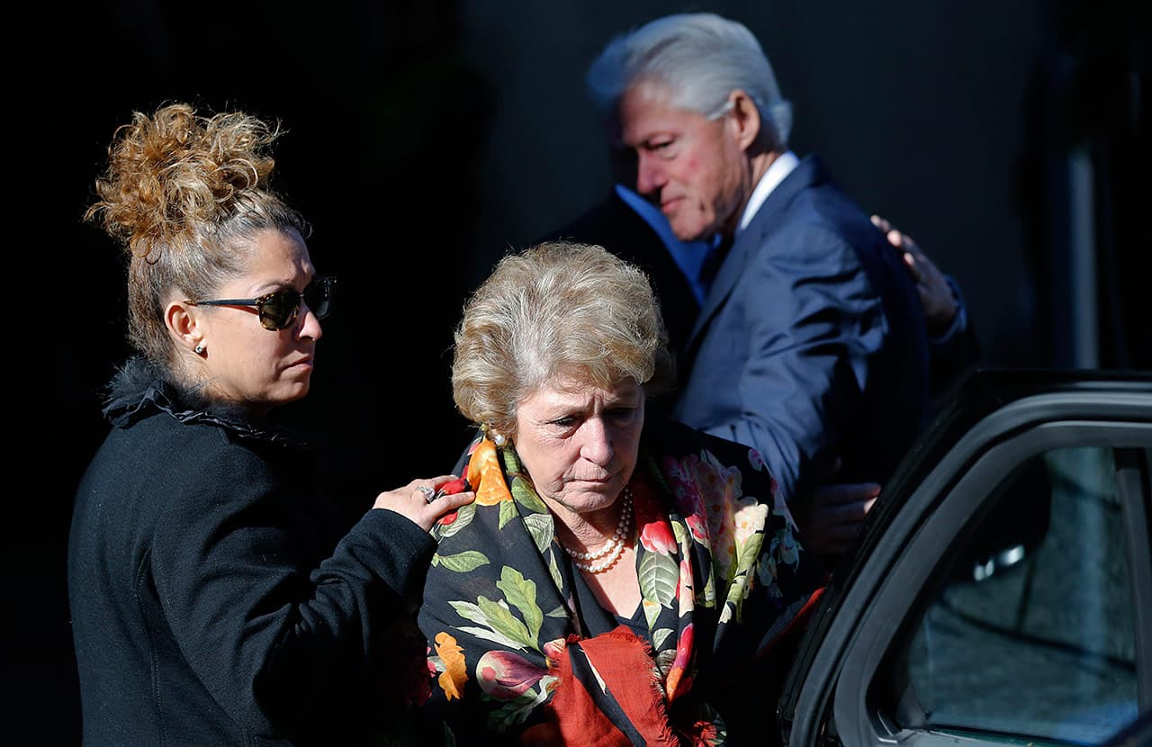 Former President Bill Clinton watches as Susan Menino Fenton, left, comforts her mother, Angela Menino, as they leave Faneuil Hall in Boston. (Elise Amendola/AP)