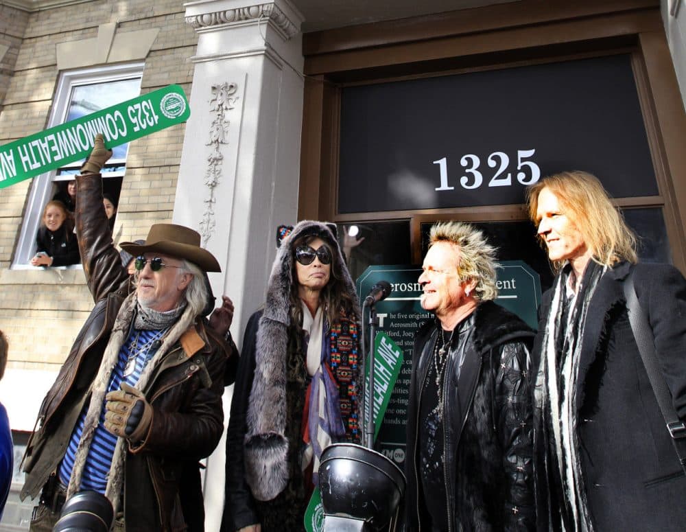 Aerosmith's Brad Whitford, Steven Tyler, Joey Kramer and Tom Hamilton Nov. 5, 2012 wave to fans at an address in Boston's Allston neighborhood which was their home in the early 1970's. (Elise Amendola/AP)
